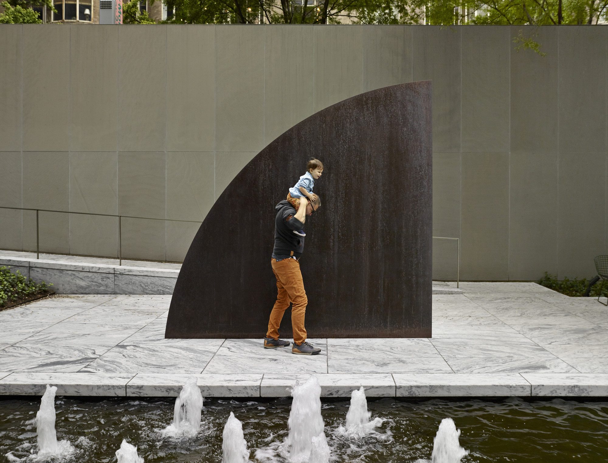 A view of the Abby Aldrich Rockefeller Sculpture Garden. Shown: Ellsworth Kelly. Curve II. 1973. Weathering steel. The Museum of Modern Art, New York. Gift of Philip Johnson. © 2020 Ellsworth Kelly Photo: Noah Kalina
